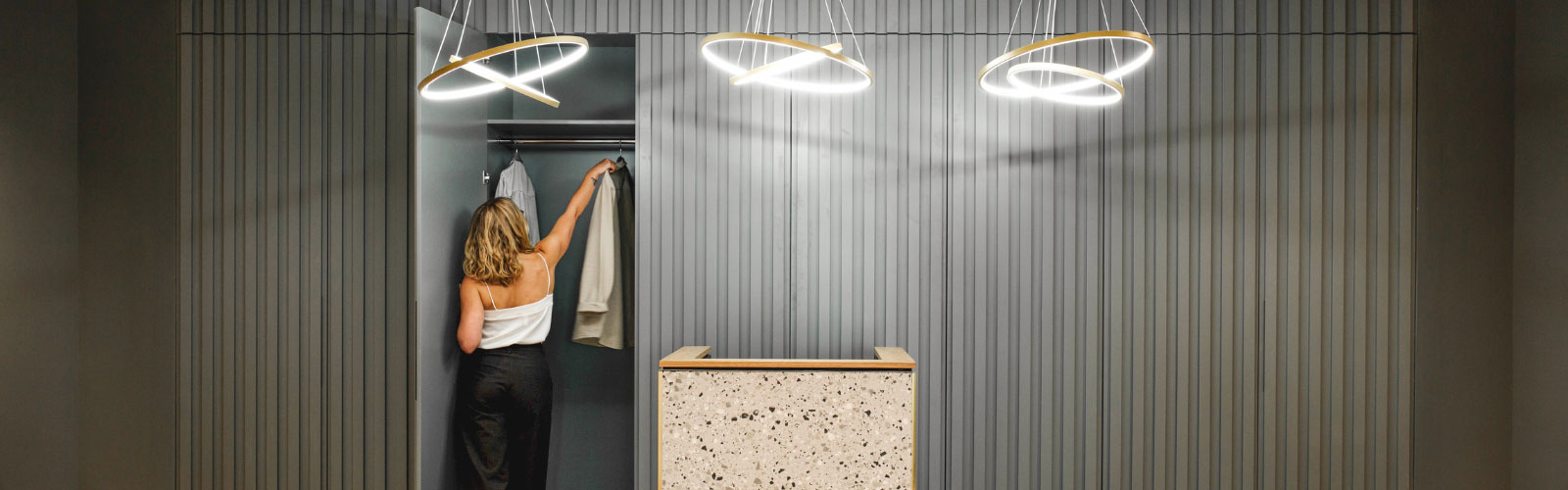 Young professional in office using sleek modern cloakroom with abstract lights 