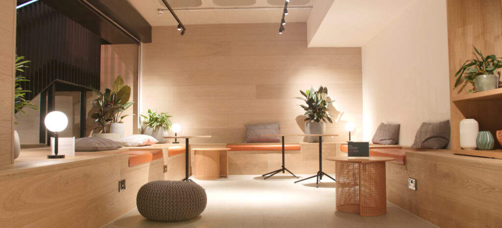 Modern office with light wood bench seating, indoor plants and ambient lighting
