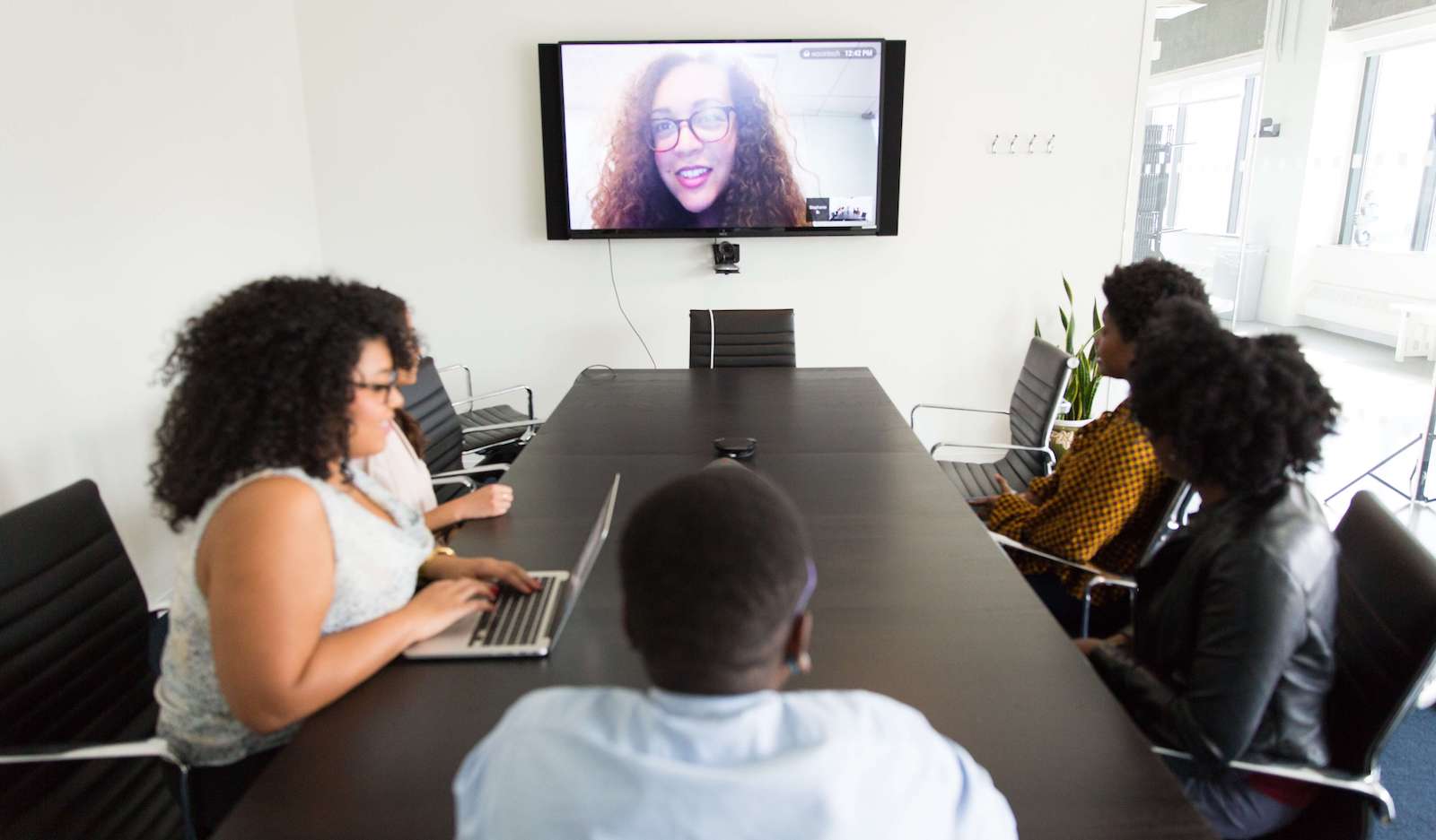 Video call taking place in a meeting room between a team