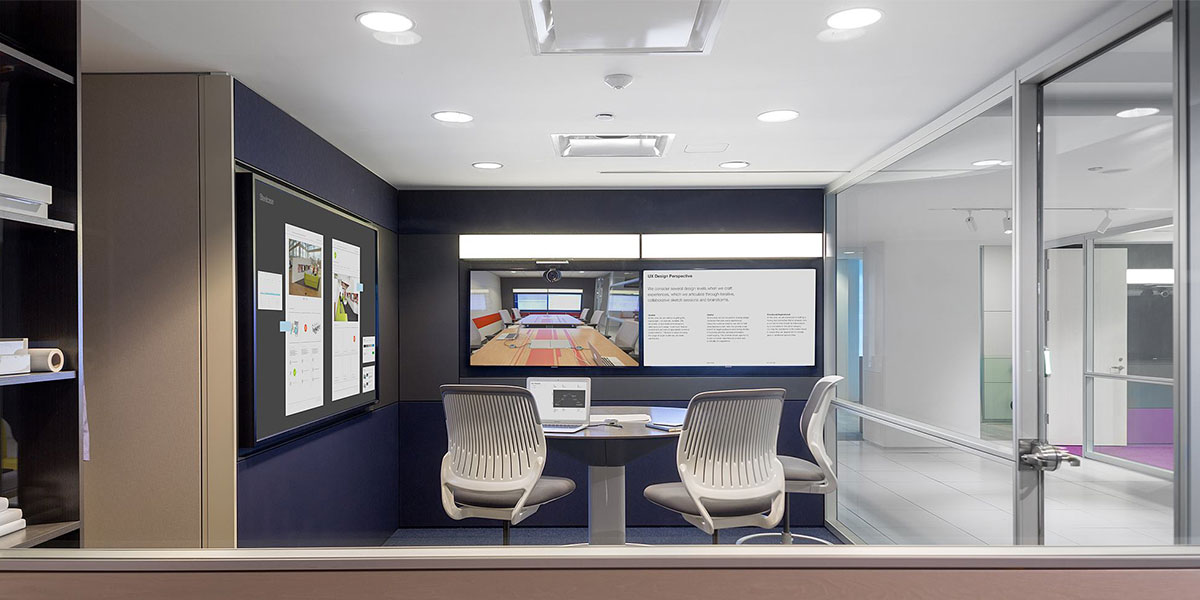 Modern office meeting room with glass walls and two grey office chairs and a screen for video calls