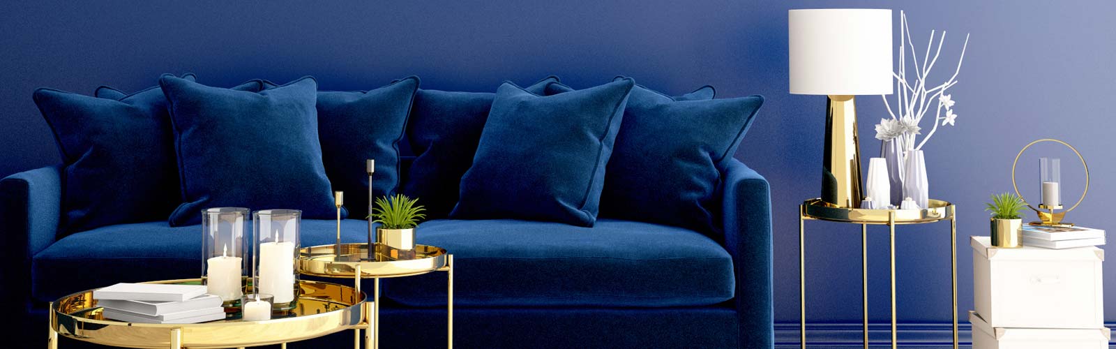 Blue velvet sofa behind gold coffee tables against blue wall in Pantone Color of the Year Classic Blue