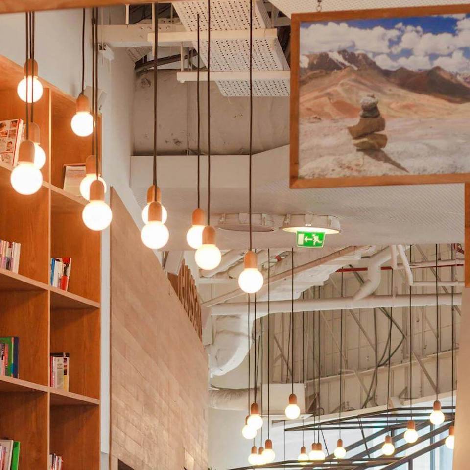 Multiple pendant lights hanging down from ceiling in front of a brown book shelf