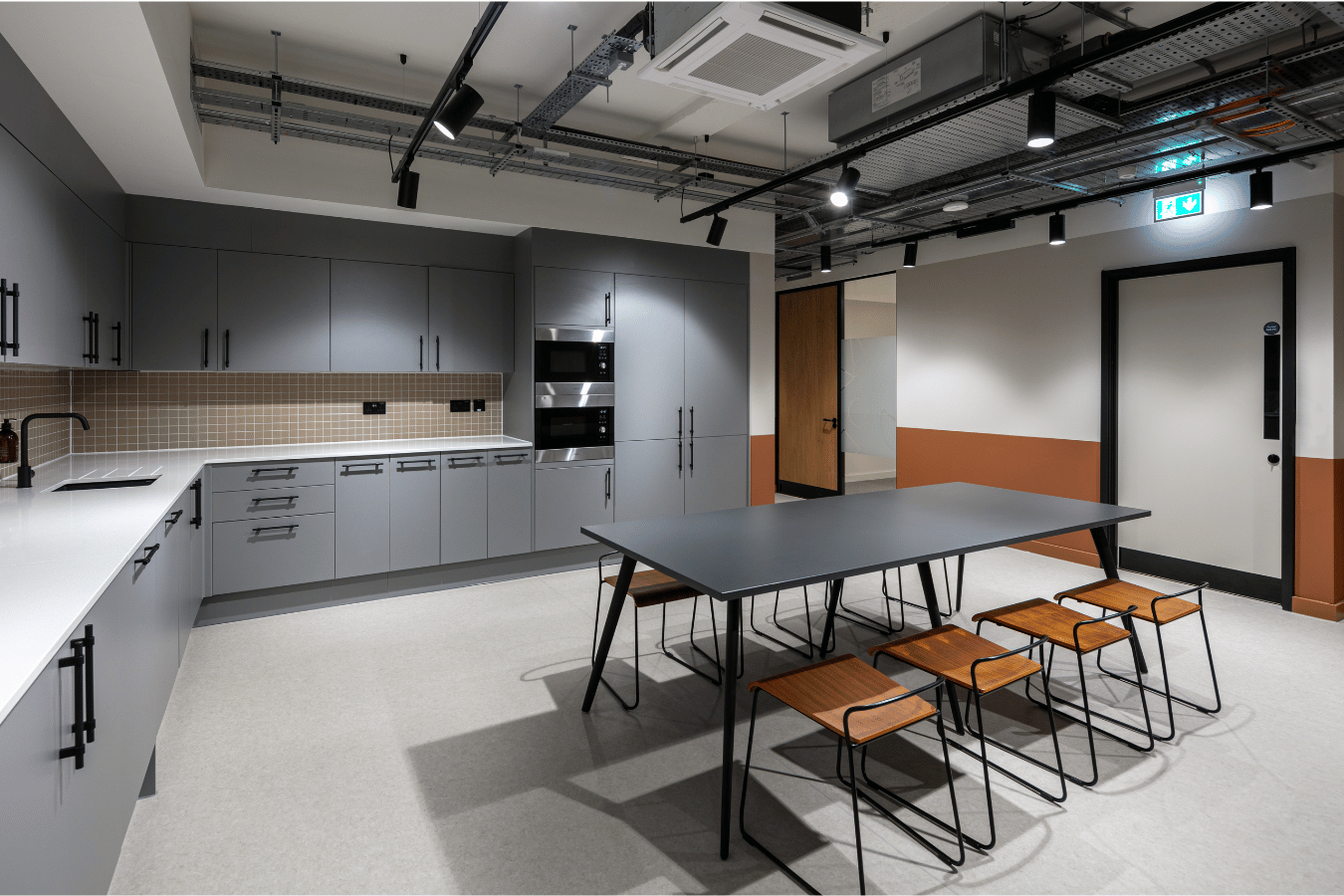 Modern work canteen with kitchen, seats and a bench