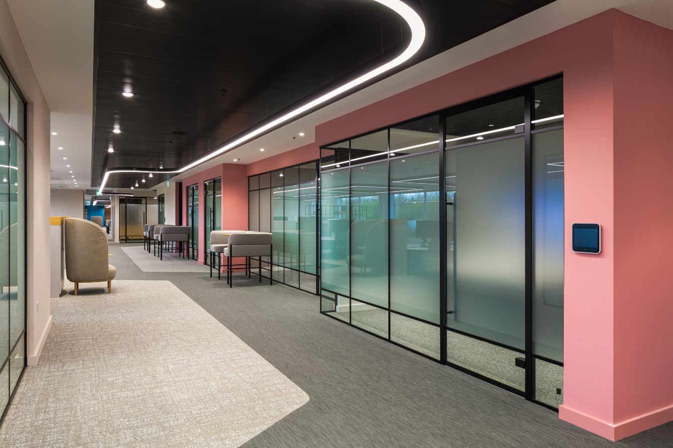 Office partitions in a modern, colourful, well-lit workspace with bespoke lighting solutions