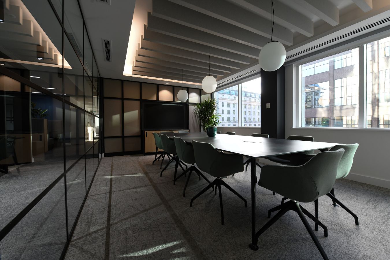 Sleek Microsoft teams/conference room with a large long meeting desk and multiple comfortable chairs