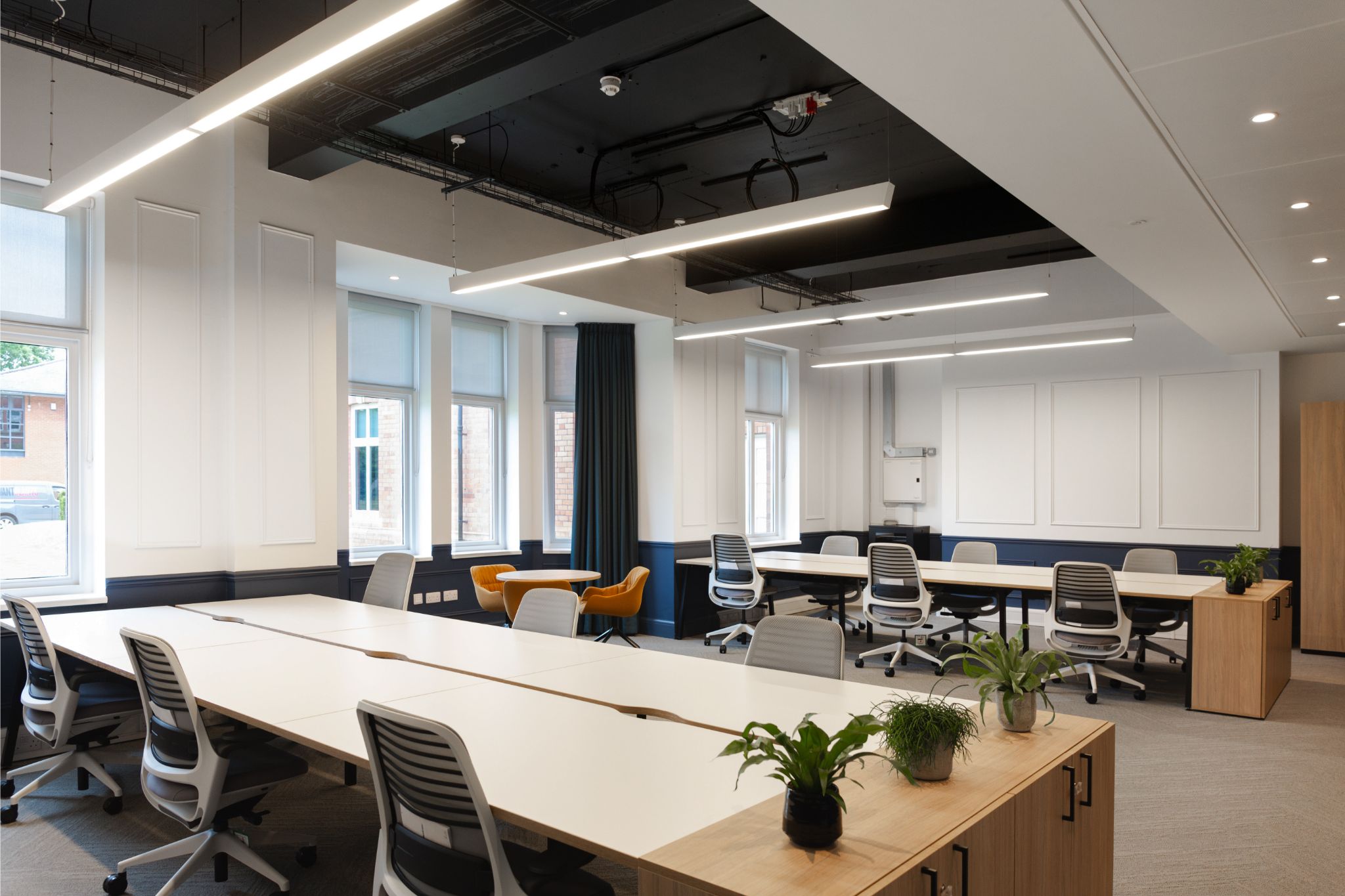 Bright modern office with line lighting and wooden storage areas