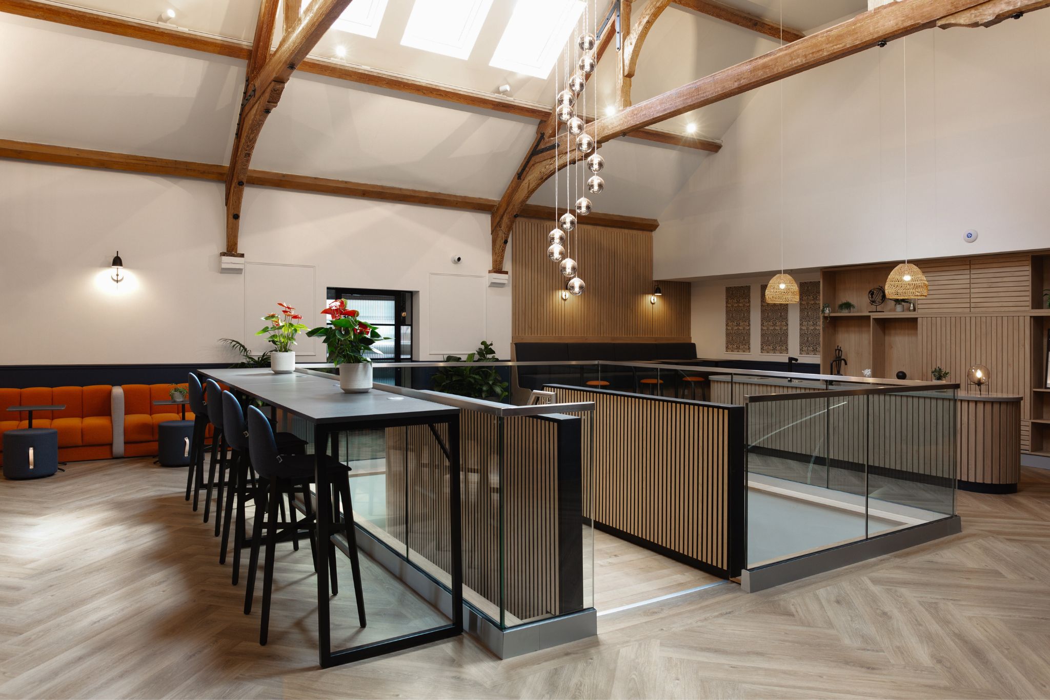 Open plan rustic inspired office common area with flood lighting and exposed wooden beams