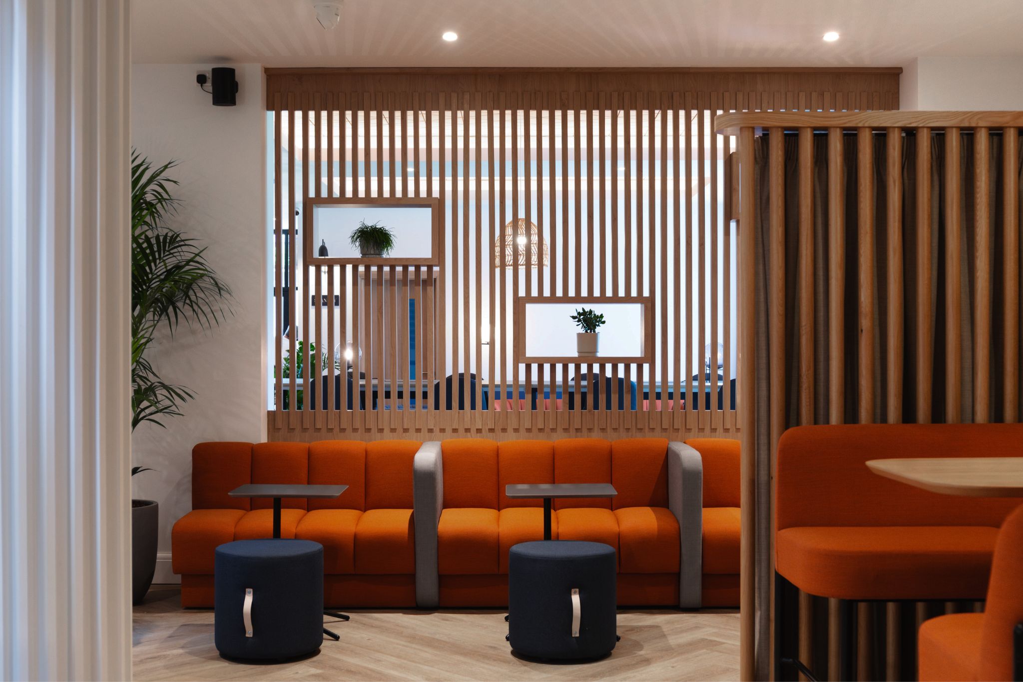 Soft seating areas with acoustic panelling in a modern office workspace