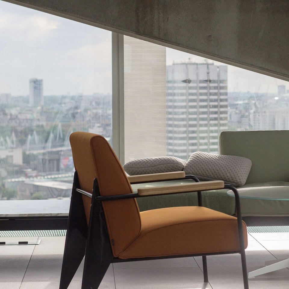 Modern office furniture against a glass window with a view over central London